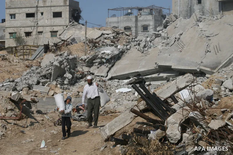 A Palestinian family sit on the rubble of their home destroyed during Israel's 22-day offensive in Jabalia in the northern Gaza Strip on February 18, 2009 APAIMAGES PHOTO / Ashraf Amra