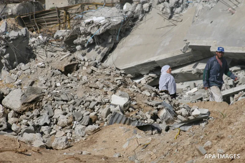 A Palestinian family sit on the rubble of their home destroyed during Israel's 22-day offensive in Jabalia in the northern Gaza Strip on February 18, 2009 APAIMAGES PHOTO / Ashraf Amra