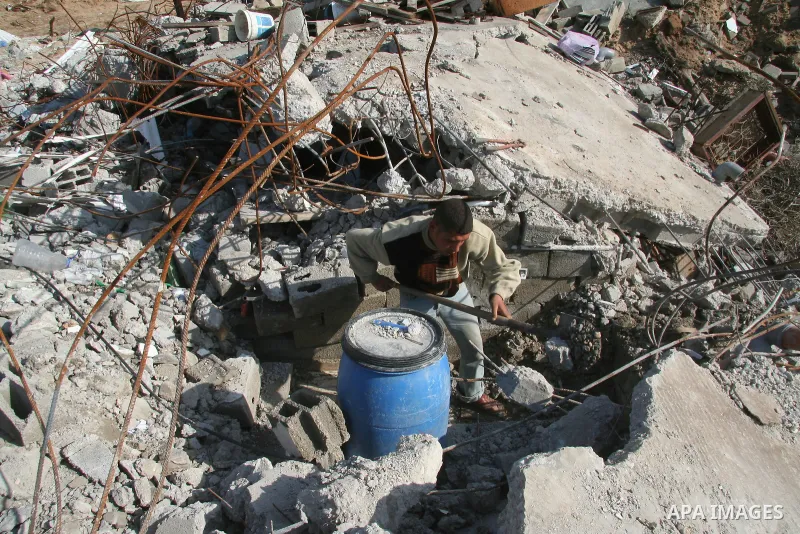 Palestinian men break the concrete debris of a house which was destroyed during Israel's 22-day offensive in Jabalia in the northern Gaza Strip on February 18, 2009 APAIMAGES PHOTO / Ashraf Amra