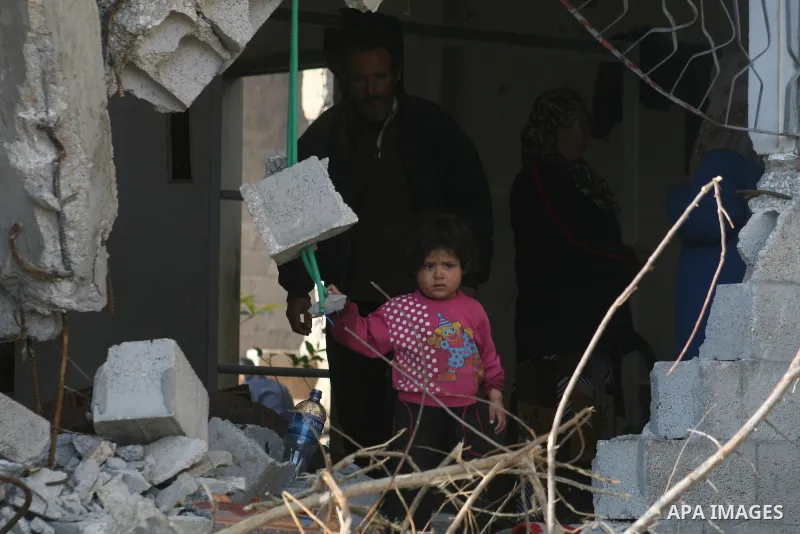 A Palestinian family sit on the rubble of their home destroyed during Israel's 22-day offensive in Jabalia in the northern Gaza Strip on February 18, 2009 APAIMAGES PHOTO / Ashraf Amra
