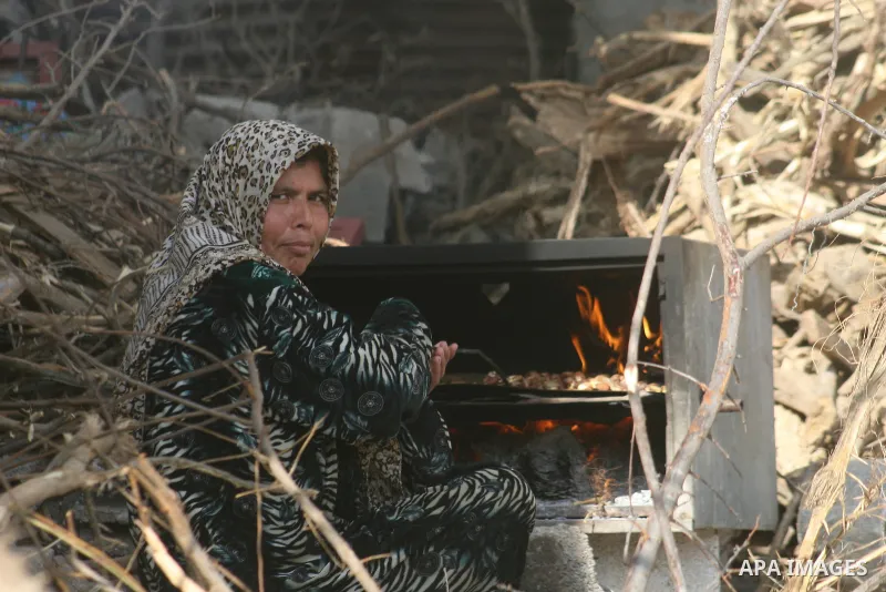 Palstinian woman cook food using fire in the northern of Gaza Strip on February 18.2009, APA IMAGES PHOTO / Ashraf Amra