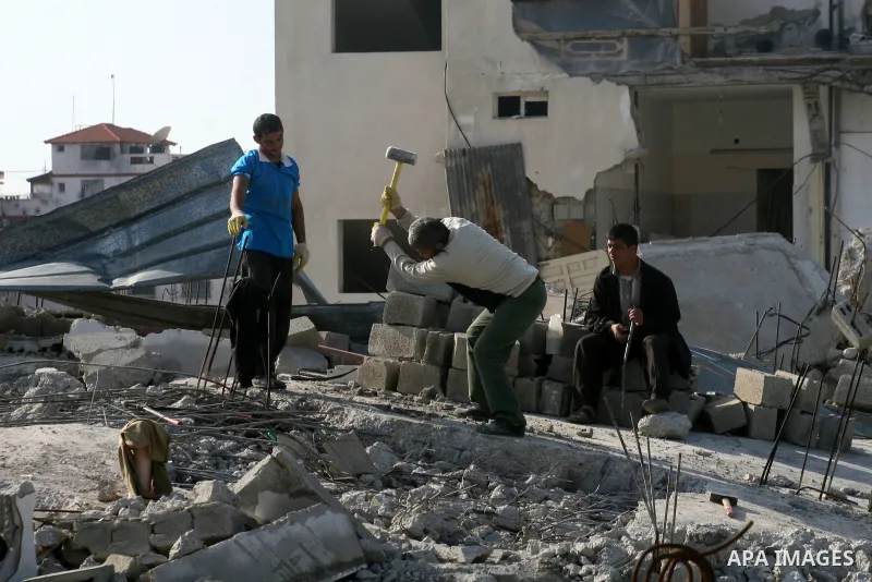 Palestinian men break the concrete debris of a house which was destroyed during Israel's 22-day offensive in Jabalia in the northern Gaza Strip on February 18, 2009 APAIMAGES PHOTO / Ashraf Amra