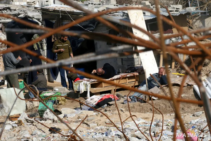 A Palestinian family sit on the rubble of their home destroyed during Israel's 22-day offensive in Jabalia in the northern Gaza Strip on February 18, 2009 APAIMAGES PHOTO / Ashraf Amra