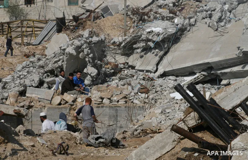 A Palestinian family sit on the rubble of their home destroyed during Israel's 22-day offensive in Jabalia in the northern Gaza Strip on February 18, 2009 APAIMAGES PHOTO / Ashraf Amra