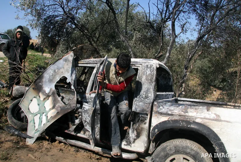 A Palestinian walks past a vehicle that according to Palestinian sources was destroyed after an Israeli air strike in Maghazi in the central Gaza Strip February 23, 2009 APAIMAGES PHOTO / Ashraf Amra