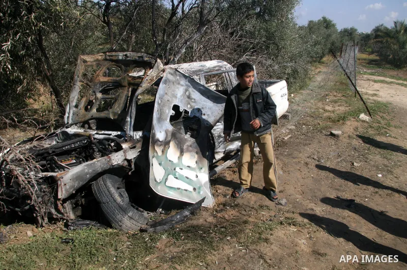 A Palestinian walks past a vehicle that according to Palestinian sources was destroyed after an Israeli air strike in Maghazi in the central Gaza Strip February 23, 2009 APAIMAGES PHOTO / Ashraf Amra