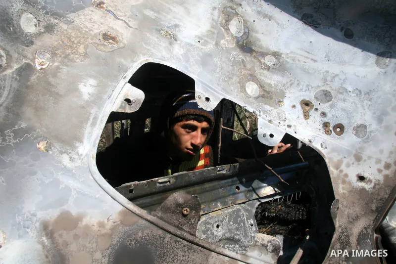 Palestinians inspect a destroyed car following an Israeli air strike in the central Gaza Strip refugee camp of Maghazi on February 23, 2009. The Israeli army carried out an air raid in the central Gaza Strip after a mili...
