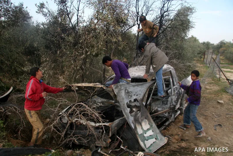 Palestinians inspect a destroyed car following an Israeli air strike in the central Gaza Strip refugee camp of Maghazi on February 23, 2009. The Israeli army carried out an air raid in the central Gaza Strip after a mili...