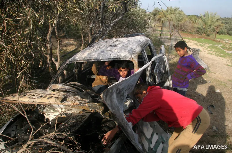 Palestinians inspect a destroyed car following an Israeli air strike in the central Gaza Strip refugee camp of Maghazi on February 23, 2009. The Israeli army carried out an air raid in the central Gaza Strip after a mili...
