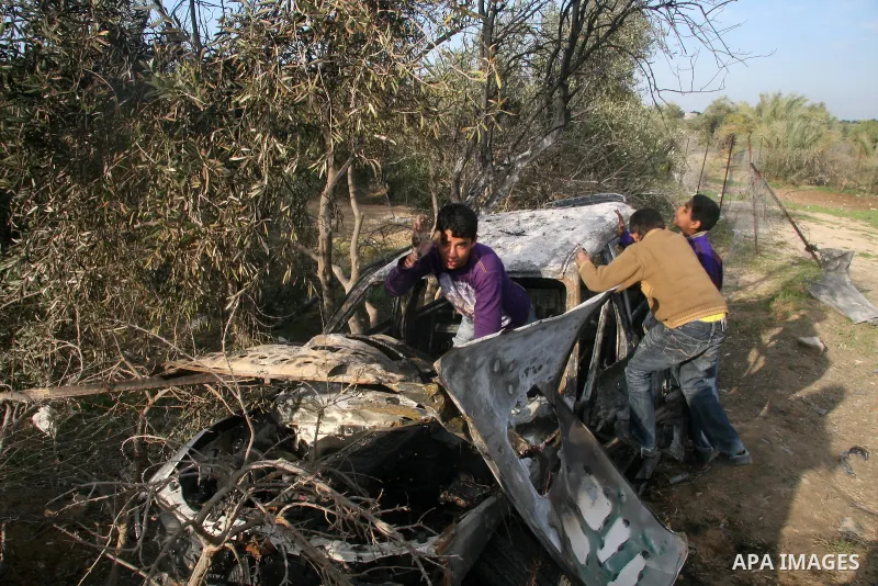 Palestinians inspect a destroyed car following an Israeli air strike in the central Gaza Strip refugee camp of Maghazi on February 23, 2009. The Israeli army carried out an air raid in the central Gaza Strip after a mili...