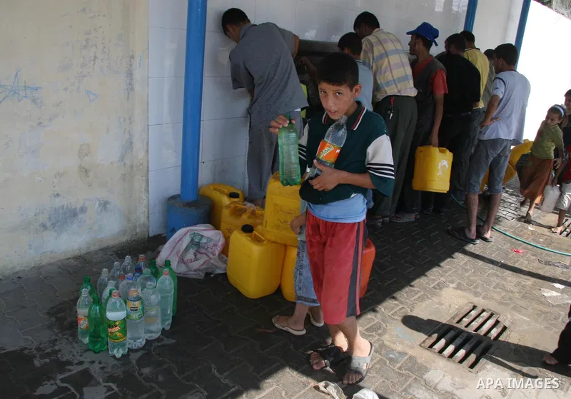 Palestinians fill their bottles by potable water at a water purification station in Rafah, southern Gaza Strip. Palestinians suffer from the lack of the potable water due to israeli stealing by pumping the potable water...