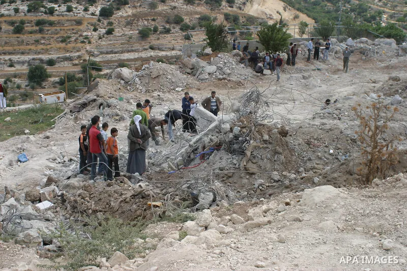 Palestinians search in the rubble at the site of a destroyed house where a Hamas militant was killed during an exchange of fire with Israeli troops, in the West Bank city of Hebron. Israeli troops killed a Hamas militant...