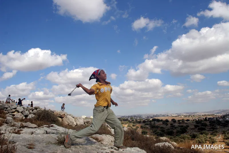 Palestinian youths hurl stones at Israeli soldiers during a demonstration against the construction of the controversial Israeli cement barrier in the West Bank village of Nilin near Ramallah.