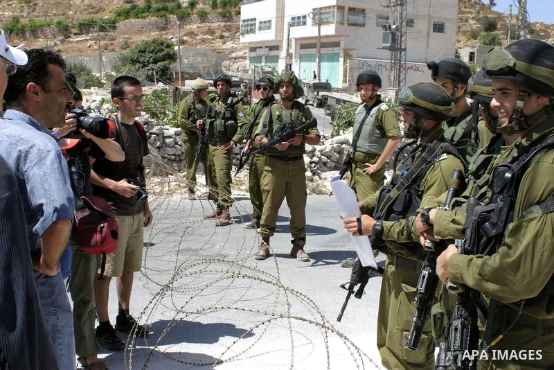 Israeli soldiers monitor a demonstration by Palestinian and foreign activists against the construction of the controversial Israeli separation barrier in the village of Maasarah near the West Bank city of Bethlehem. Isra...