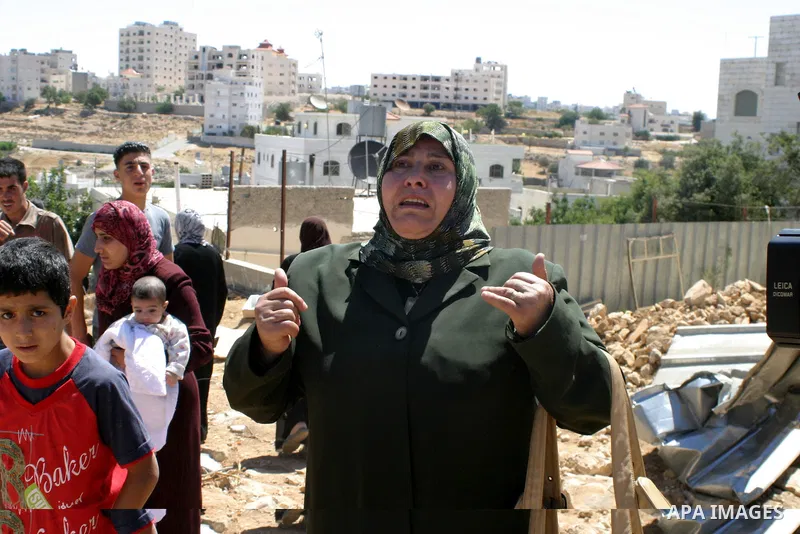 Palestinians react as they inspect their destroyed house of Jamal Karameh in the West Bank town of Hebron. According to Palestinian witnesses, Israeli forces raided two houses and arrested several men during an early mor...