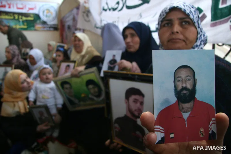 Palestinian women hold portraits of jailed relatives during a protest at the Red Cross offices in Gaza City to demand the release of Palestinian prisoners held in Israeli jails on March 30, 2009. More than 11000 Palestin...