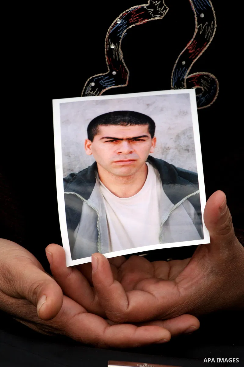 Palestinian Gamila Saramah, 36, holds a portrait of her brother Hamdallah, 35, who is being held in an Israeli jail, during a protest calling for the release of Palestinian prisoners from Israeli jails, in the West Bank...