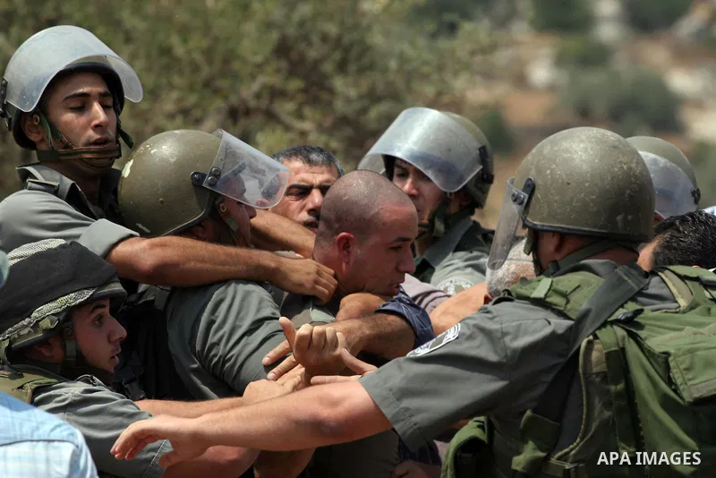 Israeli soldiers scuffle with Palestinian and international protestors during a demonstration against the construction of the controversial Israeli cement barrier in the West Bank village of Nilin near Ramallah. Sixteen...