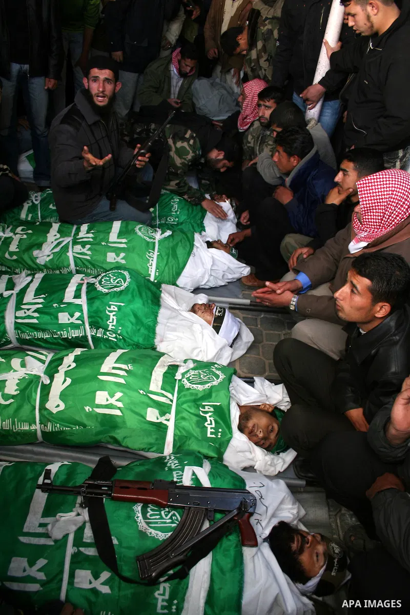 Palestinians mourn next to the bodies of Hamas militants, who were killed in an Israeli air strike on Tuesday, during their funeral in the southern Gaza Strip. Israeli forces killed nine Hamas militants in the Gaza Strip...