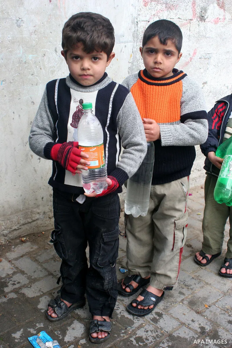 Palestinian children hold water bottles in Japaliya refugee camp, northern Gaza Strip. Palestinians buy water in the Jabaliya refugee camp following the stalling of the water pumping station due to the recurrence of powe...