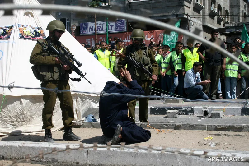 Palestinians enact a scene in which Israeli soldiers arrest Palestinians, during a protest organized by Hamas in Jabalya in the northern Gaza Strip April 17, 2009. In solidarity with Palestinian prisoners held in Israeli...