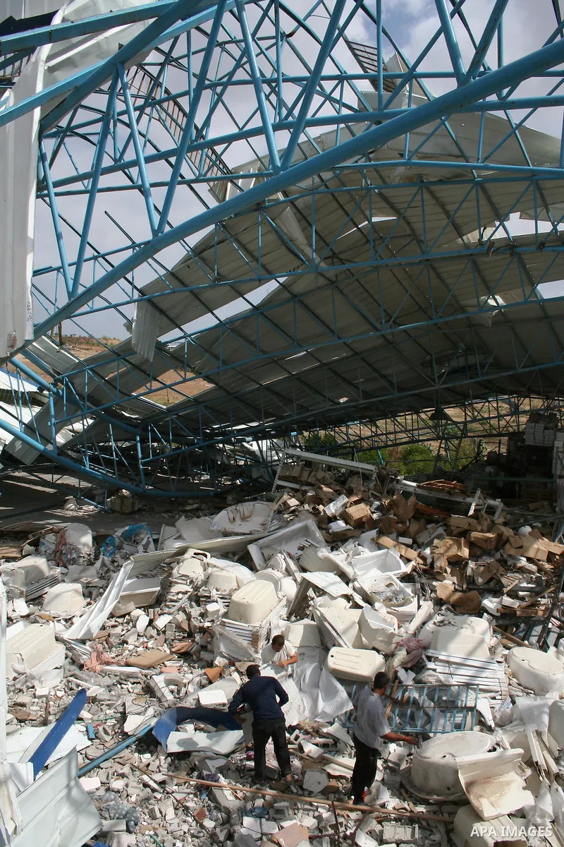 Palestinian workers remove items from a mountain of rubble at Al-Haddad tile factory in Jabalia in the northern Gaza Strip on April 30, 2009, a day before World Labour Day (May Day). At least 10 workers lost their jobs w...