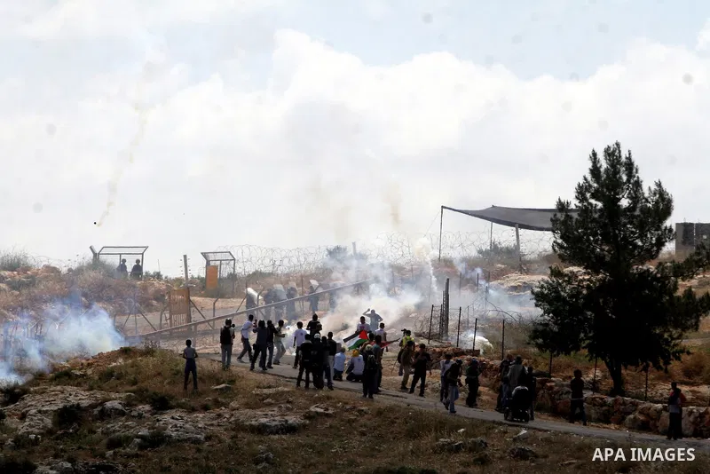 Israeli soldiers fire tear gas towards Palestinian demonstrators and foreign peace activists during a protest against Israel's controversial separation barrier in the West Bank village of Bilin, near Ramallah, on May 1,...