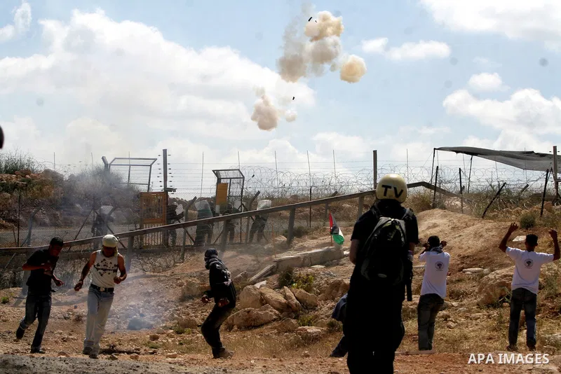 Israeli soldiers fire tear gas towards Palestinian demonstrators and foreign peace activists during a protest against Israel's controversial separation barrier in the West Bank village of Bilin, near Ramallah, on May 1,...