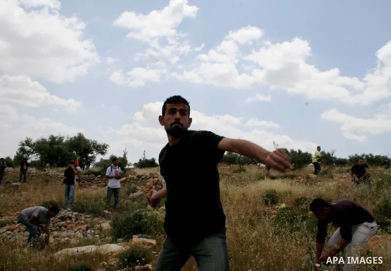 Palestinian activists throw stones at Israeli soldiers during a protest against Israel's controversial separation barrier in the West Bank village of Bilin, near Ramallah, Friday, May 1, 2009.APAIMAGES PHOTO /Issam Rimaw...