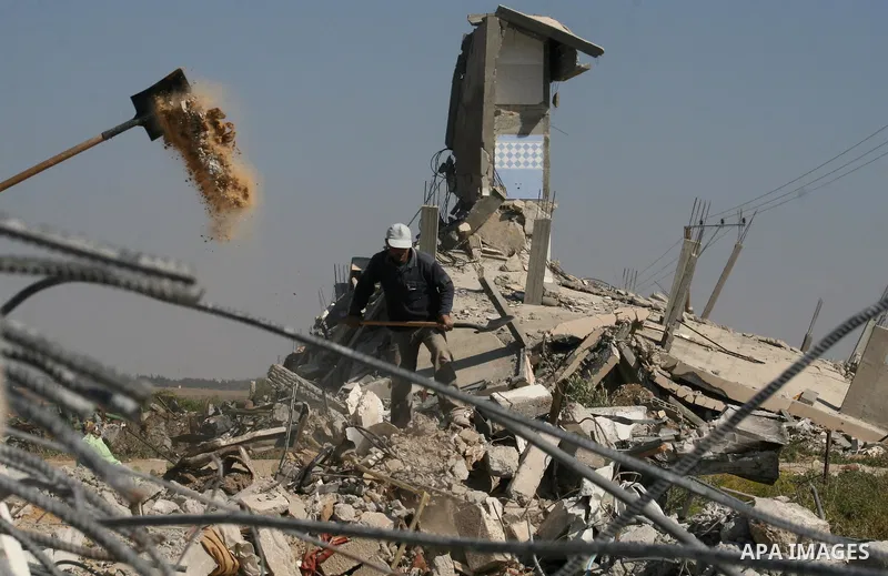 Palestinian men clean the rubble of their houses that were destroyed during Israel's 22-day offensive, in Jabalia refugee camp in the northern Gaza Strip on May 5, 2009. Israel blasted a harsh UN report on its three-week...