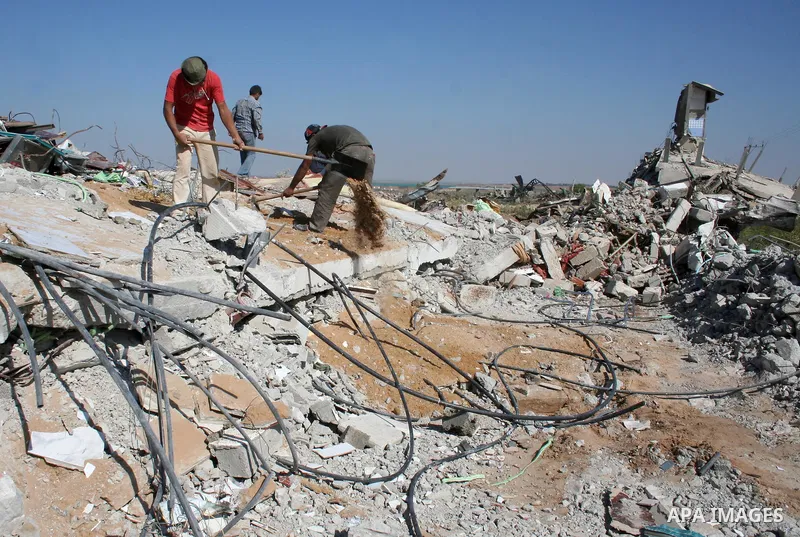 Palestinian men clean the rubble of their houses that were destroyed during Israel's 22-day offensive, in Jabalia refugee camp in the northern Gaza Strip on May 5, 2009. Israel blasted a harsh UN report on its three-week...