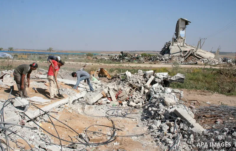 Palestinian men clean the rubble of their houses that were destroyed during Israel's 22-day offensive, in Jabalia refugee camp in the northern Gaza Strip on May 5, 2009. Israel blasted a harsh UN report on its three-week...
