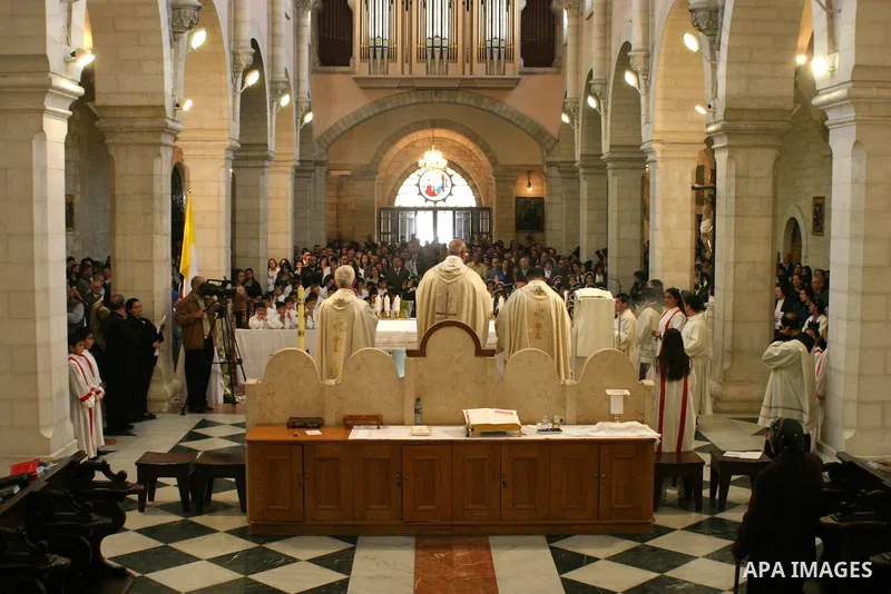 Palestinian Christians during Sunday Mass at the Church of the Nativity, traditionally believed to be the birthplace of Jesus Christ, in the West Bank city of Bethlehem, 10 May. 2009. Pope Benedict XVI on Sunday urged Mi...