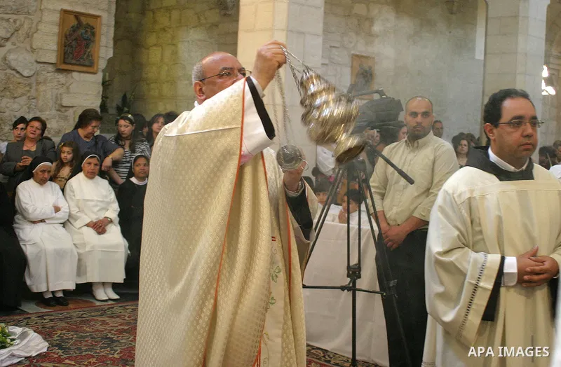 Palestinian Christians during Sunday Mass at the Church of the Nativity, traditionally believed to be the birthplace of Jesus Christ, in the West Bank city of Bethlehem, 10 May. 2009. Pope Benedict XVI on Sunday urged Mi...