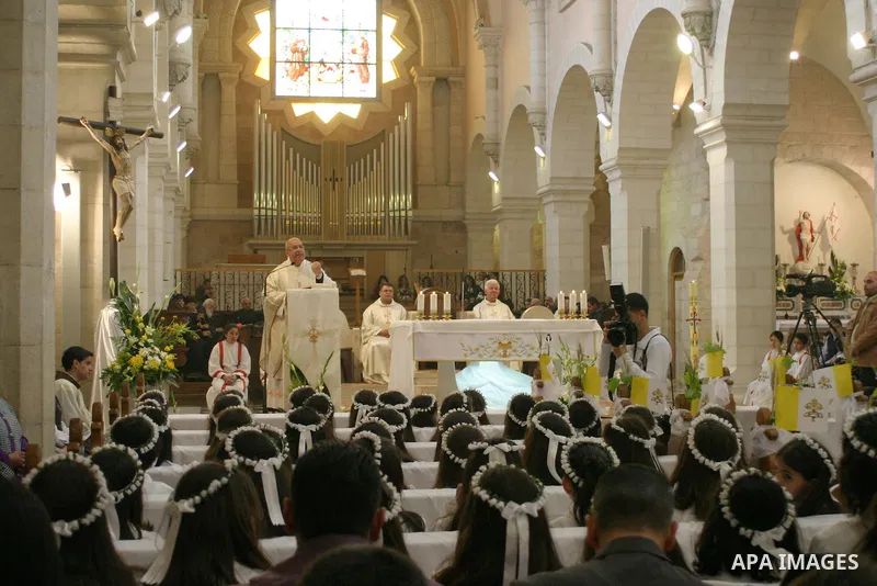 Palestinian Christians during Sunday Mass at the Church of the Nativity, traditionally believed to be the birthplace of Jesus Christ, in the West Bank city of Bethlehem, 10 May. 2009. Pope Benedict XVI on Sunday urged Mi...