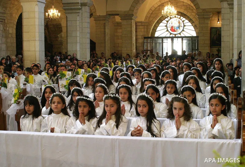 Palestinian Christian girls pray during Sunday Mass inside the Church of the Nativity, traditionally believed to be the birthplace of Jesus Christ, in the West Bank city of Bethlehem, Sunday, May 10, 2009. Pope Benedict...