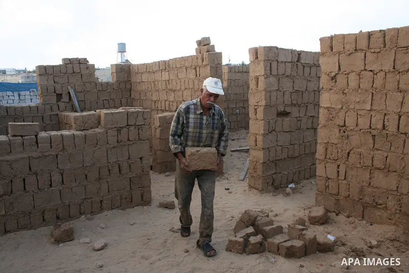 Palestinian workers use mud bricks to build a house in the southern Gaza Strip refugee camp of Rafah on May 24 2009. APAIMAGES PHOTO / Ashraf Amra