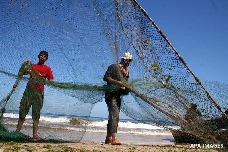 Palestinian fishermen pull their nets on the beach of Gaza City on May 30, 2009. APAIMAGES PHOTO / Ashraf Amra