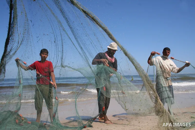 Palestinian fishermen pull their nets on the beach of Gaza City on May 30, 2009. APAIMAGES PHOTO / Ashraf Amra