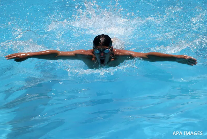 Palestinian boys jump into a swimming pool to cool off during a heat wave, in the West Bank city of Hebron on June 02, 2009. Photo \ Najeh Hashlamoun