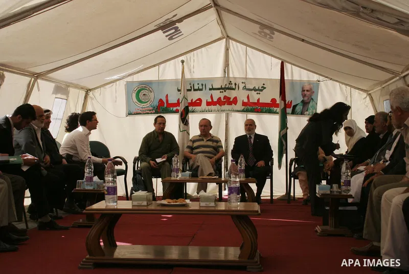 UN investigator Richard Goldstone sets with Hamas deputy Ahmed Bahrand members of his delegation in a tent as they visit the Palestinian parliament building that was destroyed during Israel's December-January offensive i...