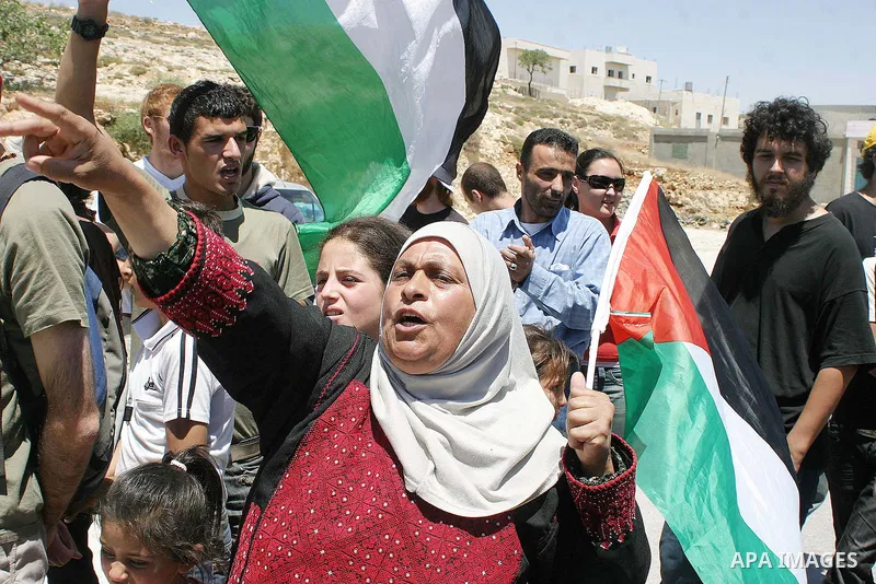 Palestinian protesters hold Palestinian flag during a demonstration against the construction of Israel's separation barrier in the West Bank village of Maasarah near Bethlehem, Friday,June 5, 2009. Photo Najeh Hashlamoun