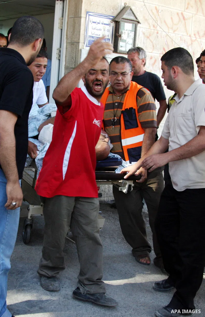 Palestinian relatives of Yussef Aqil Srour move his body after he killed by the Israeli army during a demonstration against the separation barrier in the village of Naallin at the hospital in the West Bank city of Ramall...