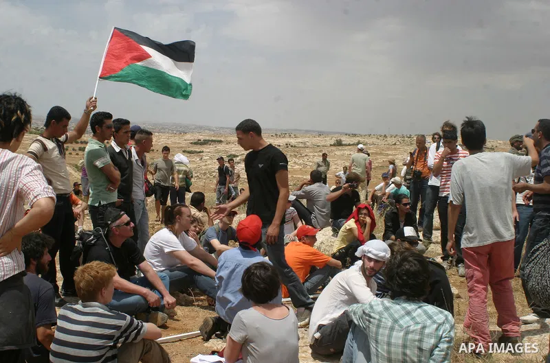 A Palestinian holds Palestinian flag during a demonstration against settlements near Sousia in the southern West Bank, south of Hebron on Saturday June 06, 2009. Photo Najeh Hashlamoun.