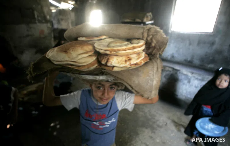 A Palestinians bake a bread in a traditional mud oven in Rafah refugee camp southern Gaza Strip on 20 June 2009. The PepsiCo Foundation and the United Nations World Food Programme (WFP) have announced a strategic partner...