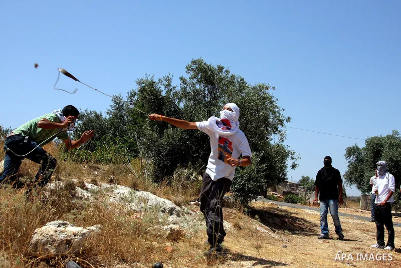 A Palestinian protesters clash with Israeli soldiers during a demonstration against Israel's controversial separation barrier in the West Bank village of Bilin near Ramallah on June 26, 2009. Photo by Issam Rimawi