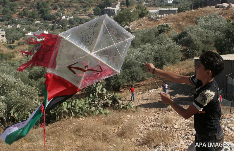 A Palestinians flying balloons over the Israeli settlement of Yitzhar during a demonstration in the village of Burin in the West Bank near the city of Nablus on July 7, 2009. Photo by Nedal Shtieh