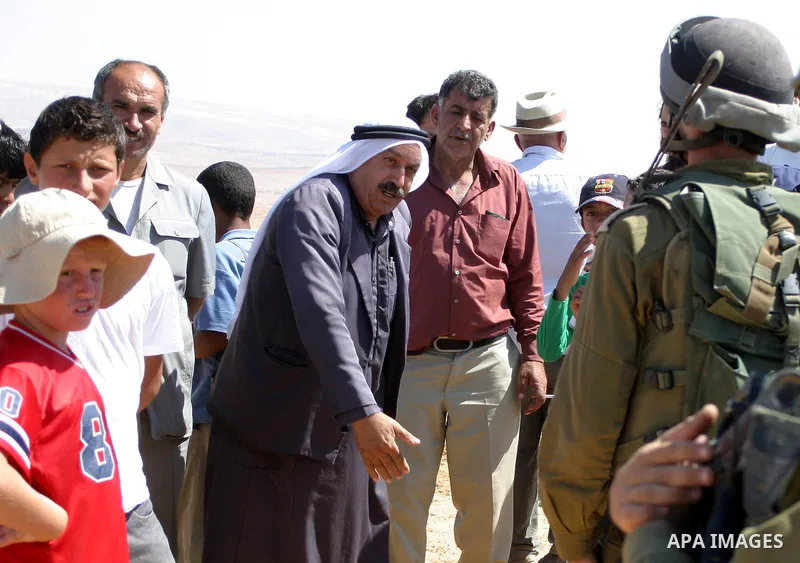 Israeli soldiers block the way of Palestinian, Israeli and international activists during the protest of the opening of a road through the land of a Palestinian which the Israeli settlers have done it near their settleme...