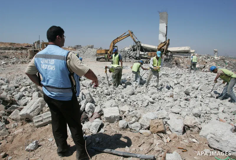 Palestinian workers of the UN Relief and Works Agency, (UNRWA), remove the rubble of a house destroyed in January 2009 during Israel's offensive on Gaza, in Jebaliya, northern Gaza Strip, July 11, 2009. Removing the rubb...