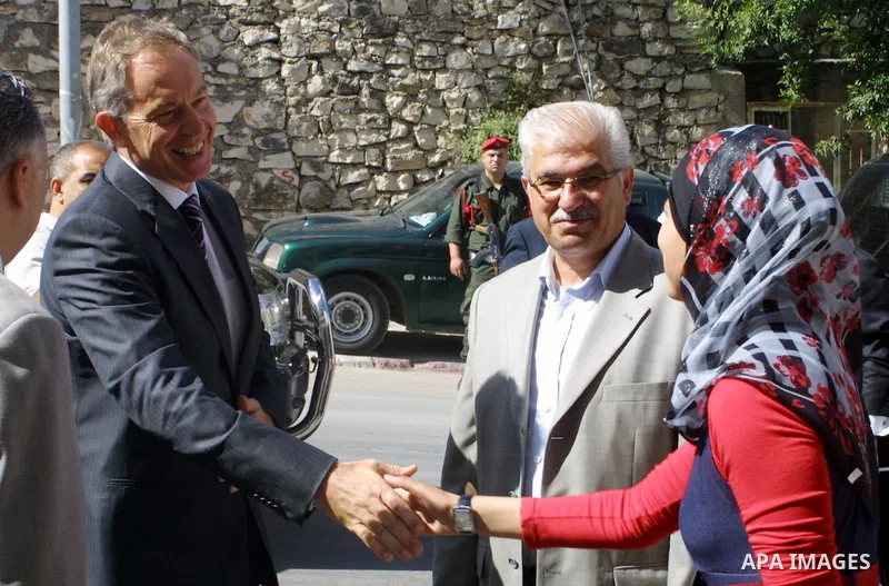 Quartet Middle East Envoy Tony Blair shakes hands with a Palestinian woman during a visit to the northern West Bank city of Nablus on July 14, 2009. Israel on May 13 rejected a European Union call for the United Nations...